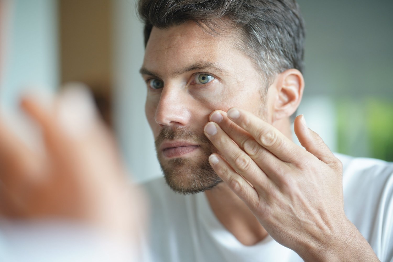 Portrait of a man in front of mirror Cosmetic Treatments for Men