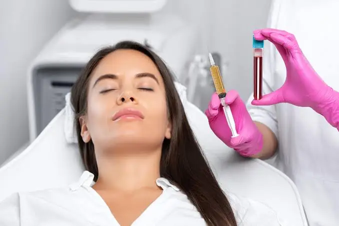 Clinician preparing a Platelet-Rich Plasma treatment, syringe and plasma vial in hand